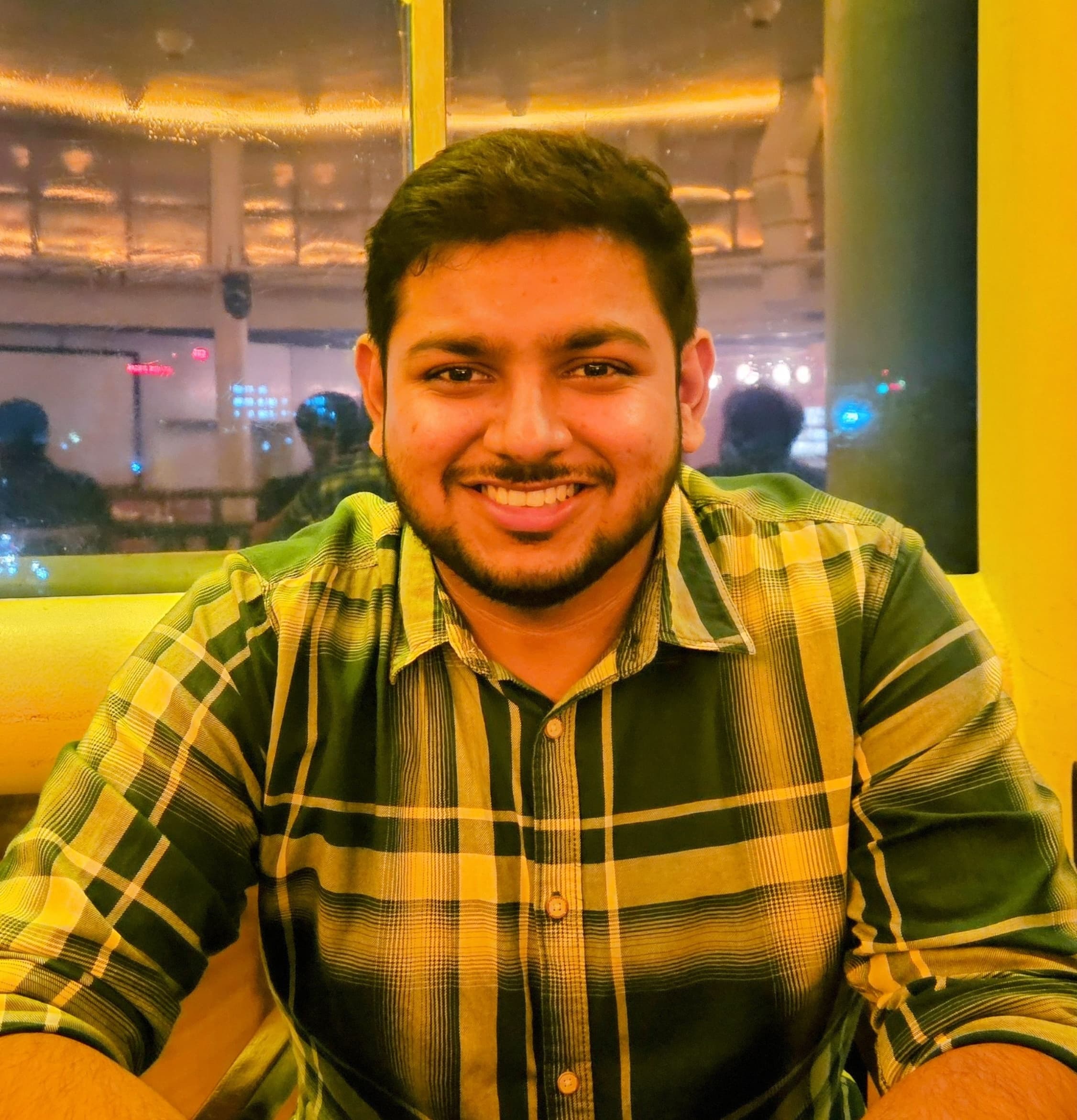 Atul Sharma smiling in a plaid shirt